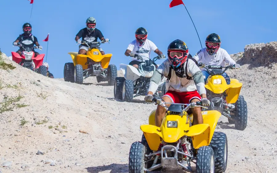 Riders on quad bikes crossing the Nellis dunes